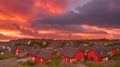 A cluster of red-roofed village houses under a dramatic evening sky