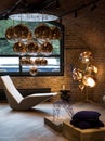 Cluster of Tom Dixon metallic pendant lights hanging in the Tom Dixon flagship store and showroom at Coal Drops Yard, Kings Cross.