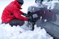 Clutching the snow chains. Snow chains on the wheels of car. man tries to put snow chains on tires Royalty Free Stock Photo