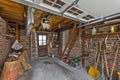 Cluttered garage of a mid century home with staircase to storage