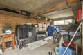 a cluttered garage with an old wood burning stove