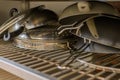 Cluttered stacking pots and pans on a cabinet rack. Royalty Free Stock Photo