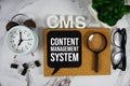 CMS - Content Management System acronym with alarm clock and magnifying glass, business concept background Royalty Free Stock Photo