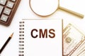 CMS Content Management System with text on notepad and office accessories on white desk Royalty Free Stock Photo