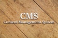 `CMS, Content Management System` white text on a wooden background.