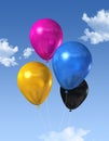 CMYK colored balloons on a blue sky