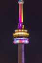 The CN Tower colorfully lit up at night with rainbow pride colors.