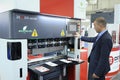 The CNC hydraulic press brake machine. Sales manager touching the switch button on the board of computer numerical control