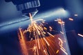 CNC laser machine cutting sheet metal with light spark. Technology plasma industrial, Blue steel color