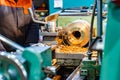 A cnc lathe worker makes a round piece of bronze