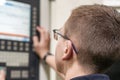 The operator of the CNC milling machine writes the program and makes adjustments for machining parts by cutting. Royalty Free Stock Photo