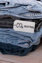 CO2 neutral emission text note on stack of jeans. Ecology nature friendly, climate change, green fuel and earth protect