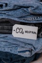 CO2 neutral emission text note on stack of jeans. Ecology nature friendly, climate change, green fuel and earth protect