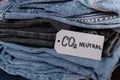 CO2 neutral emission text note on stack of jeans. Ecology nature friendly, climate change, green fuel and earth protect