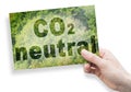 CO2 Neutral text - concept against a forest backgound and hand holding a postcard Royalty Free Stock Photo