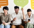 Co-workers sitting on couch and holding message icons Royalty Free Stock Photo