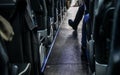 Coach bus seats seen from back row, one passenger has his foot in aisle Royalty Free Stock Photo