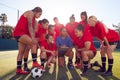Coach With Digital Tablet Discussing Tactics With Womens Football Team Training For Soccer Match