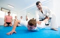 Coach explaining painful hold in taekwondo class Royalty Free Stock Photo