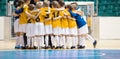 Coach giving young soccer futsal team advice before soccer tournament game stars