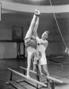 Coach helping woman on parallel bars Royalty Free Stock Photo