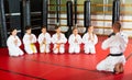 Coach in kimono tanding and greeting his students before lesson in gym Royalty Free Stock Photo