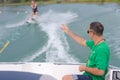 Coach making signs to female water ski student