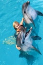 Coach swims in the water with dolphins. Royalty Free Stock Photo