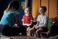 Coach talking with boy with broken arm wrapped medical cast plaster in locker room Royalty Free Stock Photo