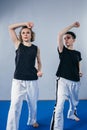 Coach teaches athlete to hit kick. Strong female martial arts athletes in their taekwon-do training. Two young women instructor