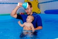 Coach teaches the baby to swim in the pool. baby splash in the water in the pool Royalty Free Stock Photo