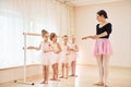 Coach teaches children. Little ballerinas preparing for performance by practicing dance moves