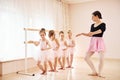 Coach teaches children. Little ballerinas preparing for performance by practicing dance moves