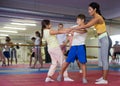 Coach teaches children to apply self-defense techniques in gym Royalty Free Stock Photo