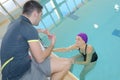 Coach training female swimmer at pool
