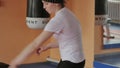The coach in training throws a ball with a female kickboxer in the sport studio