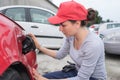 Coachbuilding sudent working on car in repairshop yard