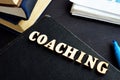 Coaching from wooden letters on a book. Mentoring