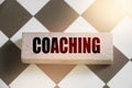 Coaching word on a wooden block put on chess board. Mentorship consulting personal achievements in career and business concept Royalty Free Stock Photo