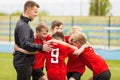 Coaching Youth Sports. Kids Soccer Football Team Huddle with Coach Royalty Free Stock Photo