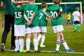 Coaching Youth Sports. Young Boys with Football Coach on Pitch