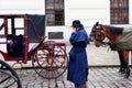 Coachman talk on a mobile phone near the horse-drawn carts