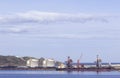 Coal cargo ship moored in port with lifting cargo cranes, ships and grain