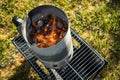 Coal of charcoal grill burning in flames with fire and lighter in barbecue chimney for BBQ evening