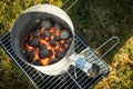 Coal of charcoal grill burning in flames with fire and lighter in barbecue chimney for BBQ evening Royalty Free Stock Photo