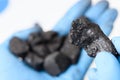 Coal lump in scientist hand and small heap in other. Royalty Free Stock Photo