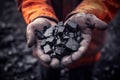 Coal mining in mine. Coal in hands of miner worker.