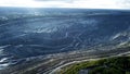 Coal mining at an open pit. Top view of the quarry. Dozers and trucks at buildings site on top aerial view