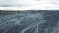 Coal mining at an open pit. Top view of the quarry. Dozers and trucks at buildings site on top aerial view