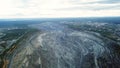 Coal mining at an open pit. Top view of the quarry. Dozers and trucks at buildings site on top aerial view